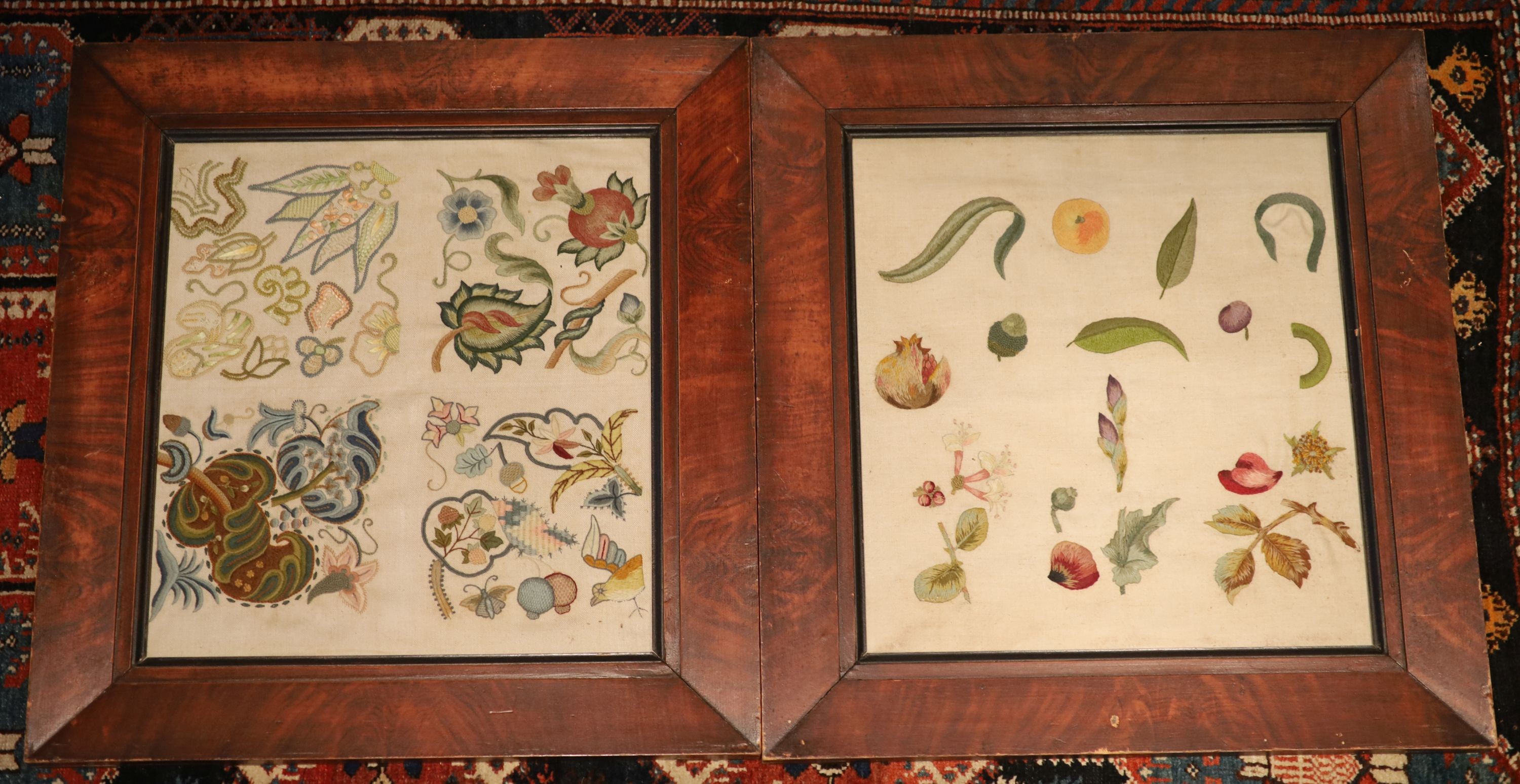 Two crewel work panels, one depicting fruits and flowers, the other quartered with foliage, 50 x 46cm, in simulated mahogany frames, overall 69 x 65cm